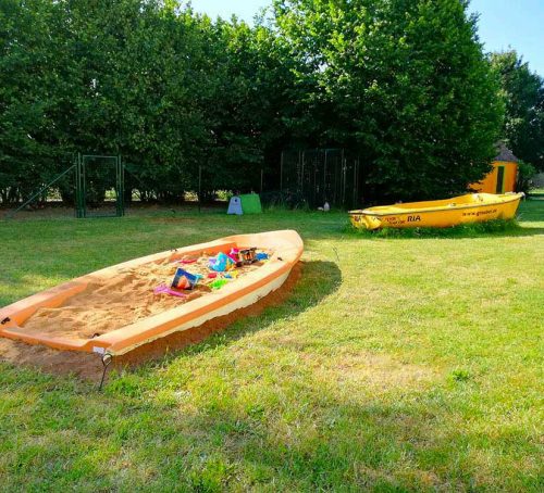 Bauernhof mit Sandkastenboot im Garten